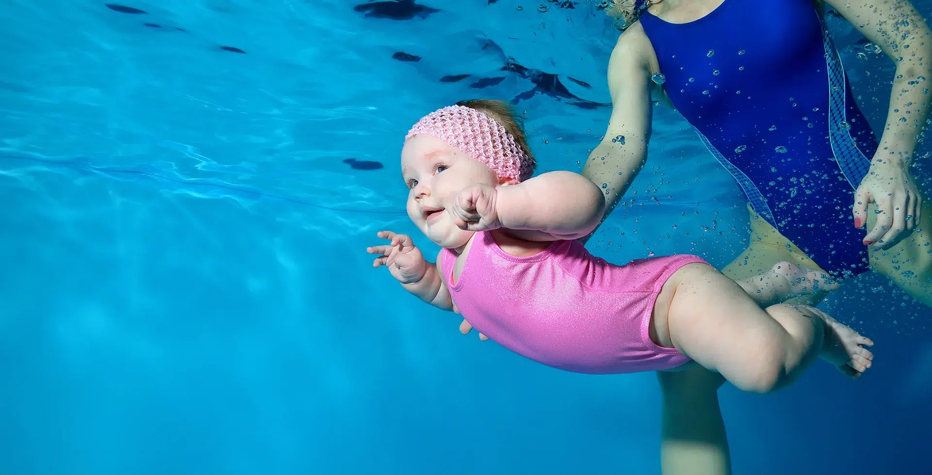 Bébé nageant sous l'eau avec assistance